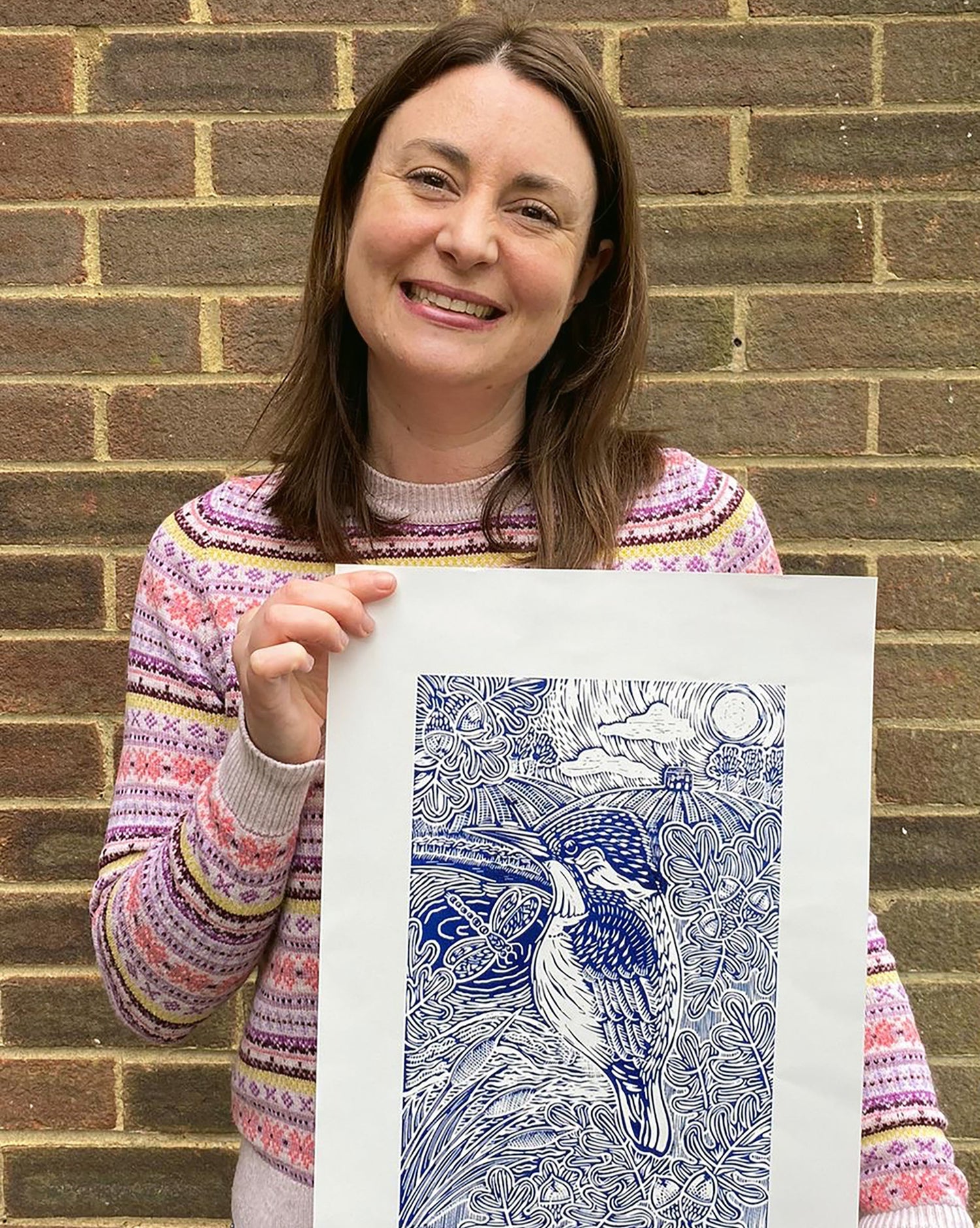 A picture of Joanna Williams holding a lino print of a kingfisher