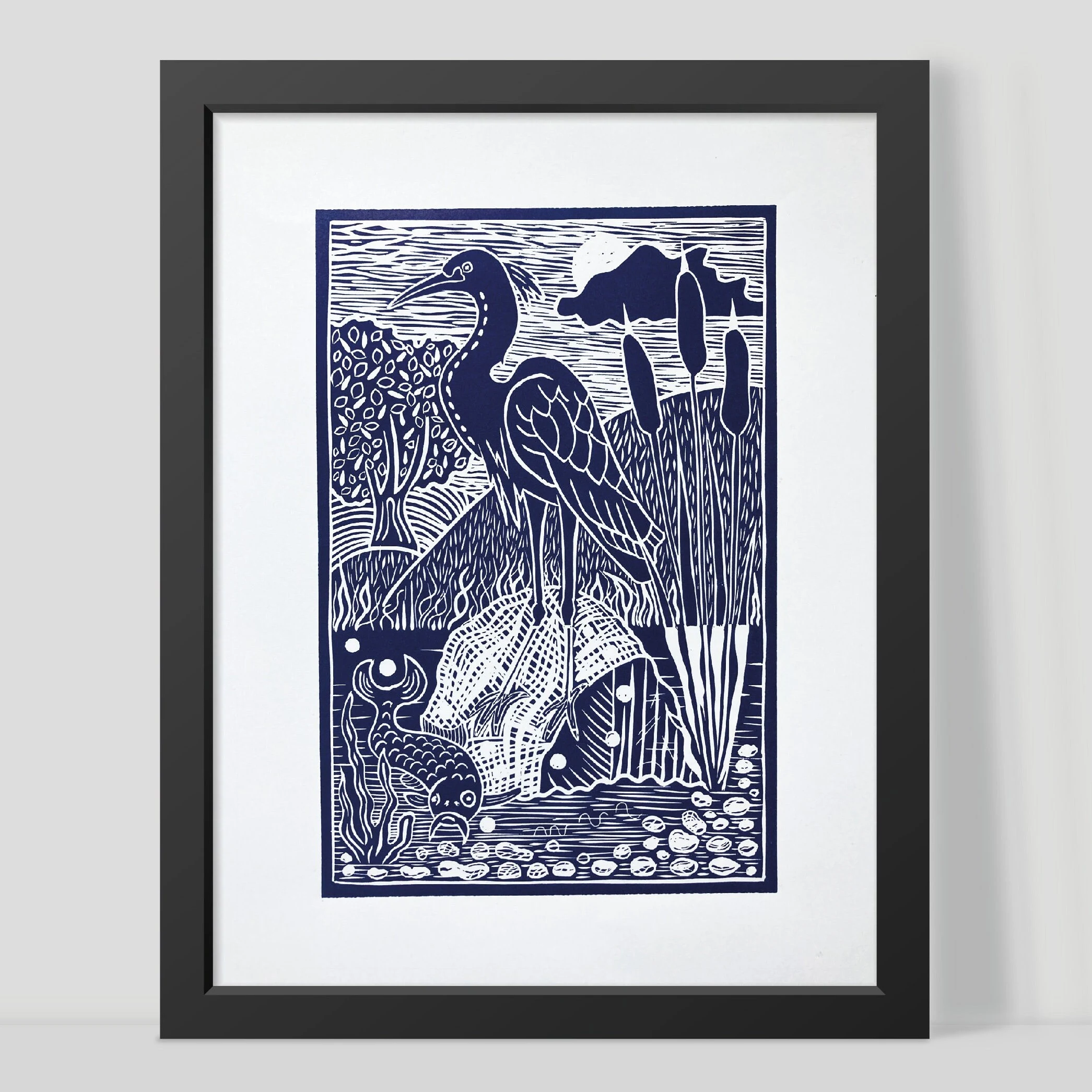 Framed artwork of a heron in a natural setting with black frame by Joanna Williams Art - lino printer.